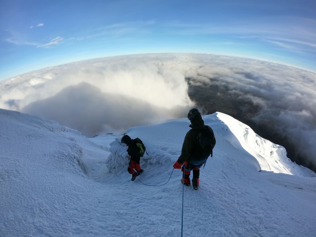 Guided climbers traversing the Cotopaxi glacier above the clouds