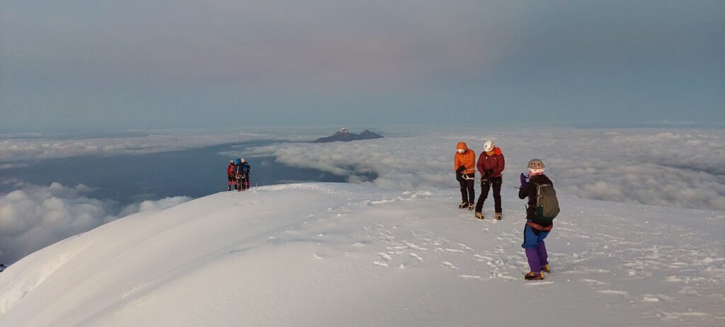 Climbers on Cotopaxi summit ridge above the clouds