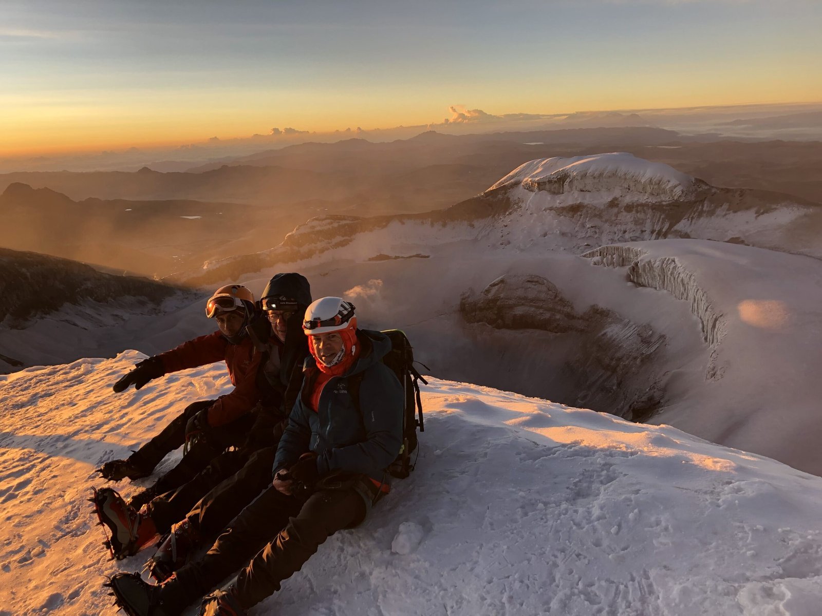Climbers resting on the Cotopaxi summit at sunrise