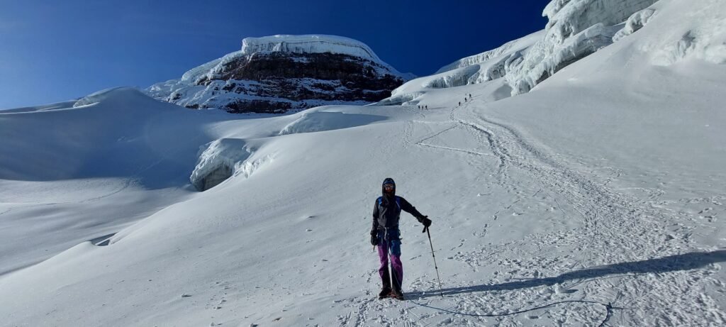 Mountaineer resting on Cotopaxi summit glacier during guided climb